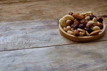 Mix of nuts and dried fruits at weathered wooden background