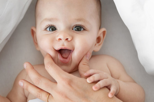 Mother squishing her baby's cheeks with hand