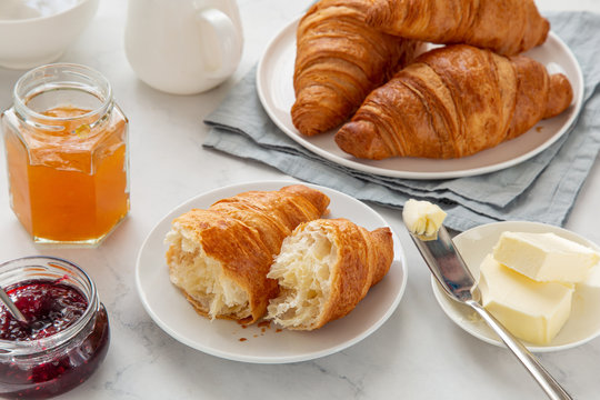 freshly baked croissants with jam and butter for breakfast