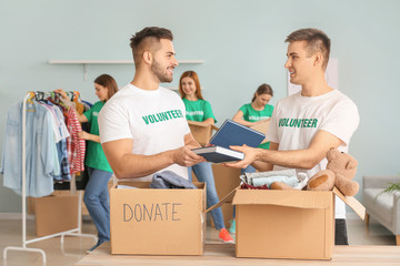 Volunteers with donations for poor people indoors