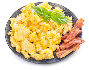 Plate with scrambled egg and bacon on white background