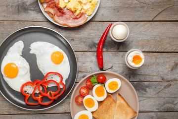 Different tasty dishes with eggs on wooden table