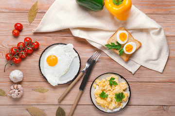 Different tasty dishes with eggs on wooden table