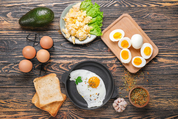 Different tasty dishes with eggs on wooden table