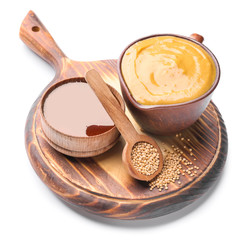 Jug of tasty honey mustard sauce with ingredients on white background