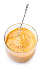 Glass of tasty honey mustard sauce on white background