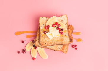 Tasty toasted bread with honey, butter and fruits on color background