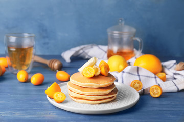 Tasty pancakes with butter and citrus fruit on table