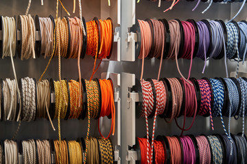 Stand with coils of multicolored textile braided cables