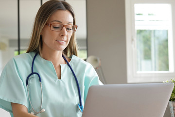 Portrait of nurse working on laptop computer