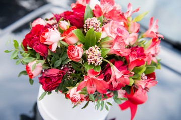 Bouquet of red flowers in a gift box in the forest