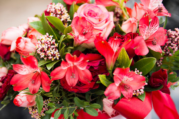 Bouquet of red flowers in a gift box in the forest
