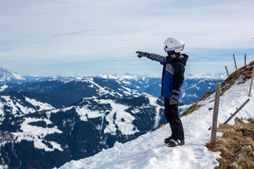 Fototapeta na wymiar Child, skiing in winter ski resort on a sunny day, enjoying sports in nature