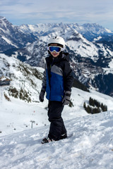 Fototapeta na wymiar Child, skiing in winter ski resort on a sunny day, enjoying sports in nature