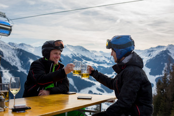 Middle aged men, drinking beer in a restaurant, while having break from skiing