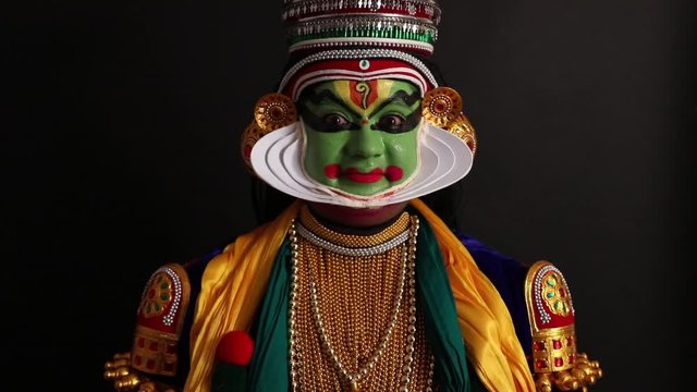 Close up face of a Kathakali dancer smiling. 