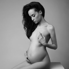 Studio fashion portrait of beautiful pregnant woman.