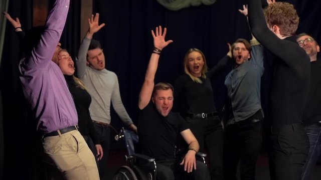 a black man and a wheelchair person together with friends carry out teamwork