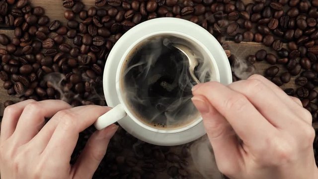 Stir coffee in a cup with a spoon. 