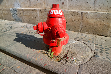 Red fire hydrant on the sidewalk of the old city of Arequipa, Peru, South America