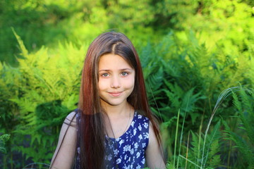 young beautiful girl in blue romper in floral print in the summer garden.  Holidays and entertainment