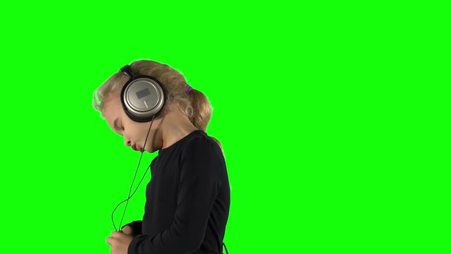 Lovely girl listening music with large headphones and singing with closed eyes