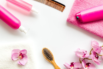 Obraz na płótnie Canvas Hair care set with shampoo and towel - pink - on white background top-down frame copy space