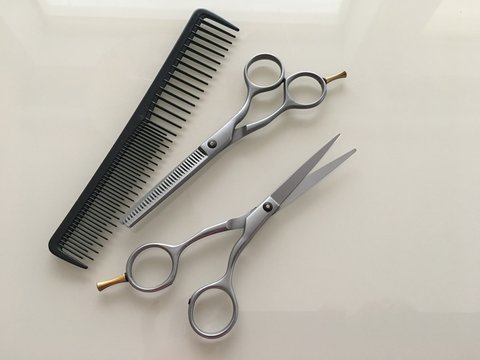 Comb and Scissors Set on a gray background for the work of a hairdresser. Photo of hairdresser tools for styling a beauty salon.