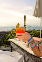 young woman on vacation in the tropics holding a nice cocktail in her hand