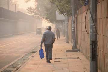 A man walking on the streets of Delhi amidst smog