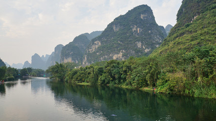 Fototapeta premium Yulong river and a weird mountains in Yangshuo, Guilin, Guangxi Zhuang Autonomous Region in China. It also known as the Little Li River. 