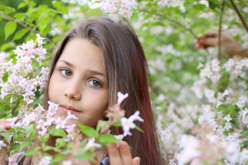 Fototapeta premium beautiful girl walks in a park where trees bloom in spring