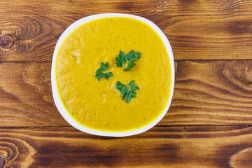 Pumpkin soup on a wooden table. Top view