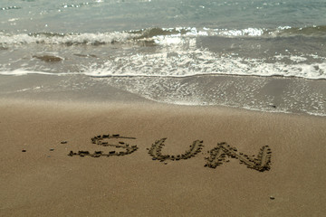 Word Sun on beach sand in sunlight