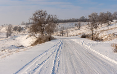 Fototapeta na wymiar Winter landscape with country slippery road near Novonikolaevka village, in central Ukraine
