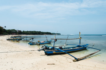 Fototapeta na wymiar Barcas de madera en una playa tropical de Indonesia un día soleado