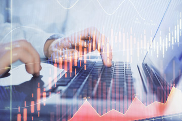 Double exposure of market chart with man working on computer on background. Concept of financial analysis.