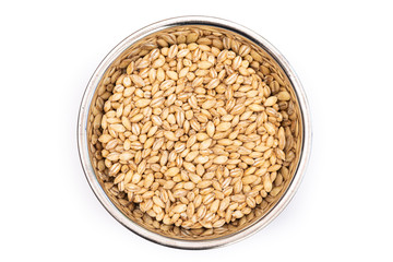 Pearl Barley from above in a stainless steel bowl, isolated on a white background. Healthy ingredient used in soups and casseroles. Naturally preserved grain with long shelf life.