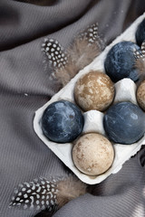 natural-dye Easter eggs lying in tray . Background with easter eggs. Naturally dyed eggs prepared for Easter on gray texture tablecloth background. Happy Easter card. 