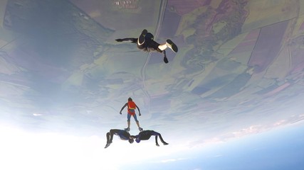 Casual. Parachutist performs an acrobatic trick in the air. Flying men make professional jump. Extreme as a hobby. 