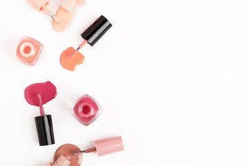 Obraz premium Unbranded small glass bottle with nail polish. Poured liquor of nail-varnish isolated on white background. Open containers of cosmetics lacquer. Copy space in right side. Manicure and pedicure concept