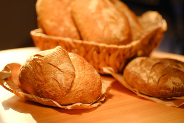 Assortment of baked bread on wooden table background. Bread background, top view of white, black and rye loaves. Healthy food. 