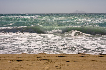 The foaming waves of the rough sea break on the beach.