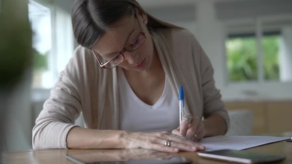 Portrait of woman writing on document