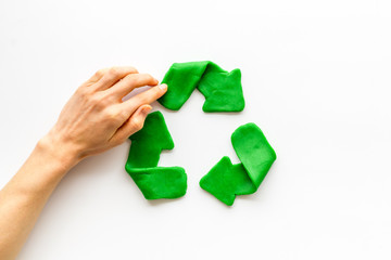 Recycling symbol - composition with hands - on white background top-down copy space