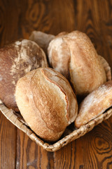 Assortment of baked bread on wooden table background. Bread background, top view of white, black and rye loaves. Healthy food. 