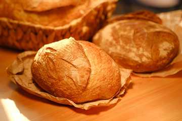 Assortment of baked bread on wooden table background. Bread background, top view of white, black and rye loaves. Healthy food. 