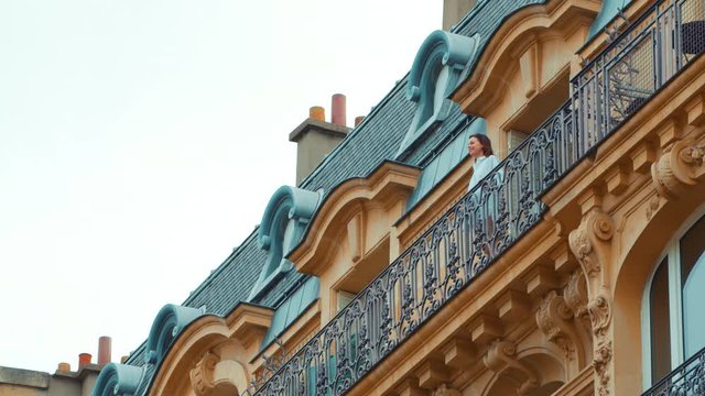 Young girl in a white shirt on a balcony in Paris, France