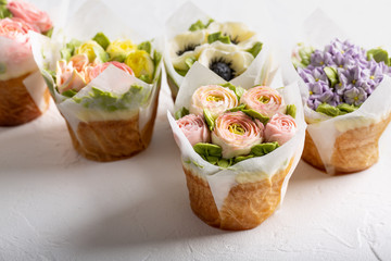 Flower cupcakes on white background. Beautiful sponge cup cakes decorated with buttercream roses.