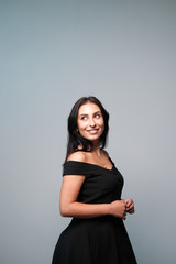 A large portrait of a middle-aged woman (30-35 years old) with dark hair and brown eyes in a black...